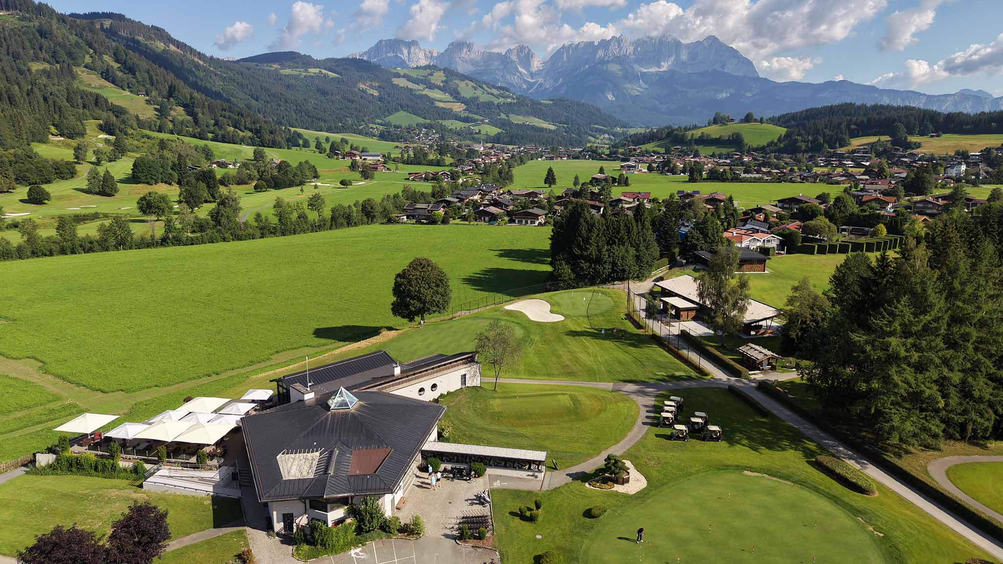 Luftaufnahme des Pro Shops am Golfclub Schwarzsee mit Wildem Kaiser im Hintergrund