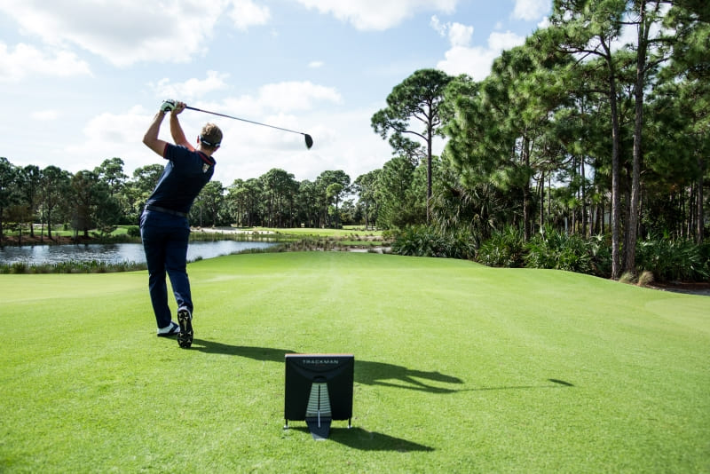 Golfer beim Abschlag mit TrackMan Launch Monitor zur präzisen Schlaganalyse auf dem Golfplatz.