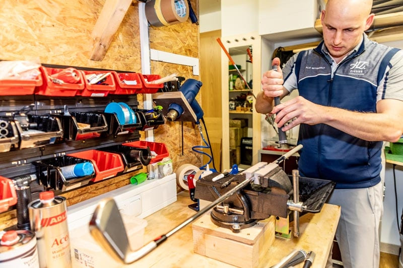 Ein Experte arbeitet an einem Golfschläger in der Werkstatt für eine individuelle Schlägeranpassung.